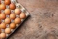 Chicken eggs in carton box on wooden table background Royalty Free Stock Photo