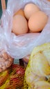 Chicken eggs inside plastic bag and red and white small onion
