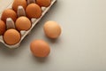 Chicken eggs in an open egg carton on grey. Top view with copy space. Natural healthy food and organic farming concept Royalty Free Stock Photo