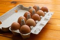Chicken eggs in a package on the table. Brown chicken eggs in a recycled paper box on a wooden background. Natural eco-friendly Royalty Free Stock Photo