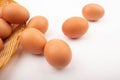 Chicken eggs in a wicker basket and scattered eggs on a white background. Close up Royalty Free Stock Photo