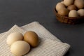 Chicken eggs in a wicker basket on the table. Eggs on a kitchen towel Royalty Free Stock Photo