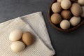 Chicken eggs in a wicker basket on the table. Eggs on a kitchen towel Royalty Free Stock Photo