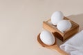 Chicken eggs in a wooden box on beige background with copy space, product with amino acids choline lecithin cholesterol calcium
