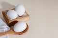 Chicken eggs in a wooden box on beige background with copy space, product with amino acids choline lecithin cholesterol calcium