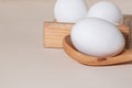 Chicken eggs in a wooden box on beige background with copy space, product with amino acids choline lecithin cholesterol calcium