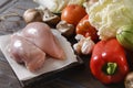 Chicken fillet on a cutting Board, fresh vegetables, zucchini, tomatoes, mushrooms, peppers, lettuce on a dark wooden Royalty Free Stock Photo