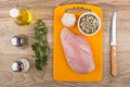 Chicken fillet on cutting board, spices, garlic and kitchen knife Royalty Free Stock Photo