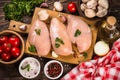 Chicken fillet with ingredients for cooking on wooden table.