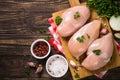 Chicken fillet with ingredients for cooking on wooden table.