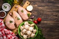 Chicken fillet with ingredients for cooking on wooden table.