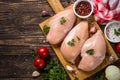 Chicken fillet with ingredients for cooking on wooden table.