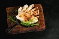 Semi-finished chicken fillets,lightly fried,on a dark background with fresh herbs.Half-finished.Quick cooking at home