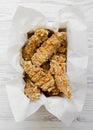 Chicken fingers in paper box on a white woodentable, top view. Flat lay, from above, overhead. Close-up