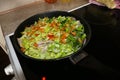 Chicken with fresh vegetables on a frying pan