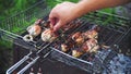 Man in nature fries chicken in a grill on charcoal