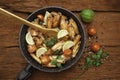 Chicken fried in skillet with wooden spatula