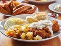 Chicken fried steak covered in gravy with sunny side up eggs and breakfast foods Royalty Free Stock Photo