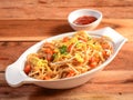 Chicken Hakka Noodles a popular oriental dish made with chicken, noodles and vegetables, served over a rustic wooden background,