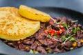 Chicken hearts with potato pancake on black plate