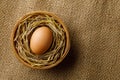 Chicken or hen egg on straw in wicker basket on sackcloth Royalty Free Stock Photo