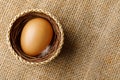 Chicken or hen egg in wicker basket on sackcloth Royalty Free Stock Photo