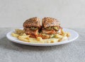 chicken jalapeno burger with fries served in a dish isolated on grey background side view of fast food