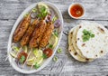 Chicken kebabs on wooden skewers on an oval plate and homemade tortilla Royalty Free Stock Photo