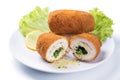 Chicken Kiev cutlet with green salad and lemon slice on a plate, white background Royalty Free Stock Photo