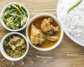 chicken korma, dal chana, chicken curry, plain rice with onion, pepper and salad served in a dish isolated on wooden table top