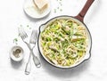 Chicken, leek, linguine pasta carbonara in a frying pan on a light background, top view. Flat lay Royalty Free Stock Photo