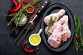 Chicken legs, drumsticks and ingredients for cooking, raw meat on black background