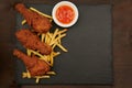 Chicken legs fast food on a slate plate with red sauce Royalty Free Stock Photo