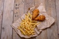 Chicken legs and french frie on wooden background