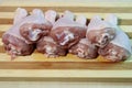 Chicken legs with greens on a wooden board.