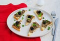 Chicken liver appetizer with salted olives on slices of toasted white bread on a light concrete plate. Offal recipes. Appetizer Royalty Free Stock Photo