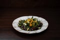 Chicken liver salad with fresh cucumber slices with bell pepper with arugula in honey sauce with sesame on a wooden table