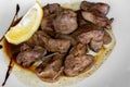 Chicken liver with wine and soy sauce, garnished with slice of lemon. Closeup.