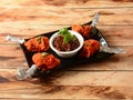 Chicken lollipop is Indian Chinese appetizer served over a wooden rustic background. selective focus