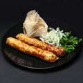 Chicken lula kebab with greens on a black plate on a black background Royalty Free Stock Photo