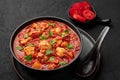 Chicken Madras Curry in black bowl on dark slate table top. Indian cuisine dish with. Asian food and meal Royalty Free Stock Photo