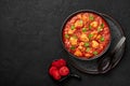 Chicken Madras Curry in black bowl on dark slate table top. Indian cuisine dish with. Asian food and meal Royalty Free Stock Photo