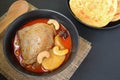 Chicken Massaman curry served with roti parata or roti canai on the table.