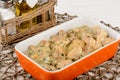 Chicken meat baked with bechamel sauce on wooden table.