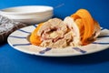 Chicken meat roulade stuffed with cheese and ham, sliced carrot on plate,towel,plates