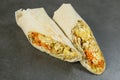 Chicken meat shawarma isolated on dark stone background. Gyros wrapped in lavash bread Royalty Free Stock Photo