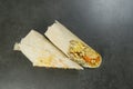 Chicken meat shawarma isolated on dark stone background. Gyros wrapped in lavash bread Royalty Free Stock Photo