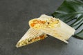 Chicken meat shawarma with monstera Leaf on dark background. Gyros wrapped in lavash bread Royalty Free Stock Photo