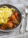 Chicken meatballs in tomato sauce and fettuccine pasta in a brown bowl Royalty Free Stock Photo