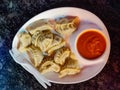 Chicken momo served with sauce in a white plate. Top view